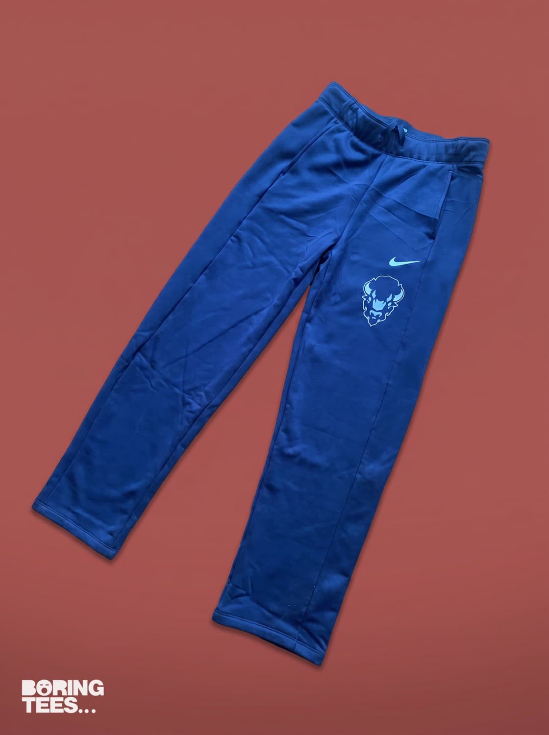 Royal blue Nike joggers with a light blue Bison mark on the thigh
