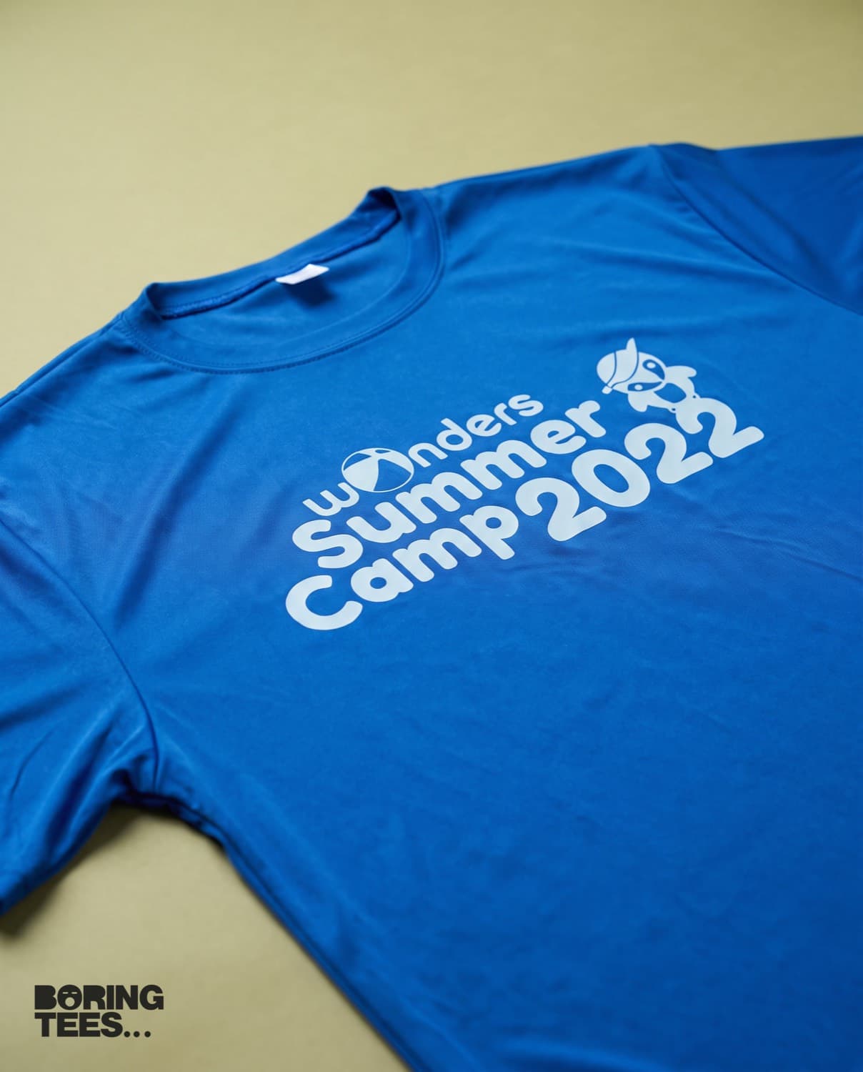 Royal blue performance tee with a large white Wonders Summer Camp 2022 print across the front